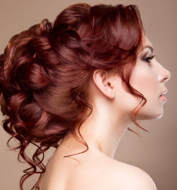Coiffure tendance raffinée sur cheveux roux avec chignon moderne Coiffure tendance à Capbreton avec chignon sophistiqué sur cheveux roux bouclés